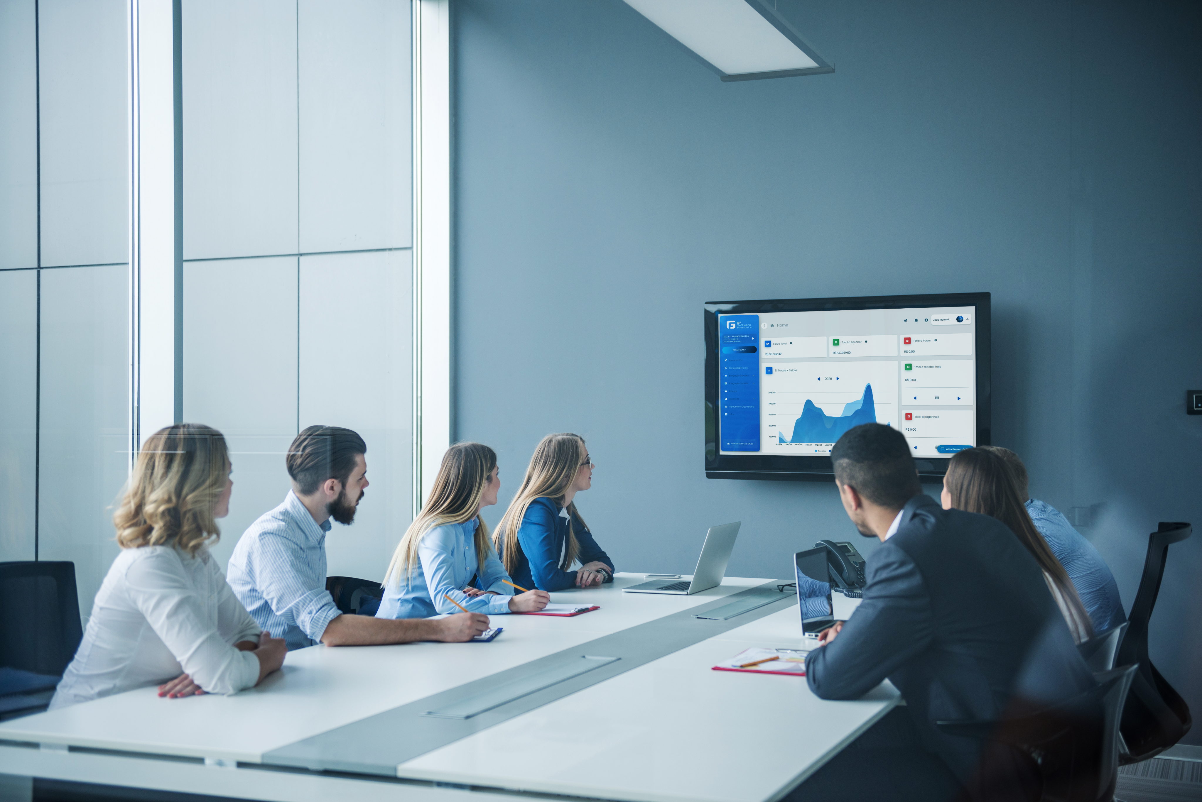Pessoas analisando gráficos e dados em uma tela de computador